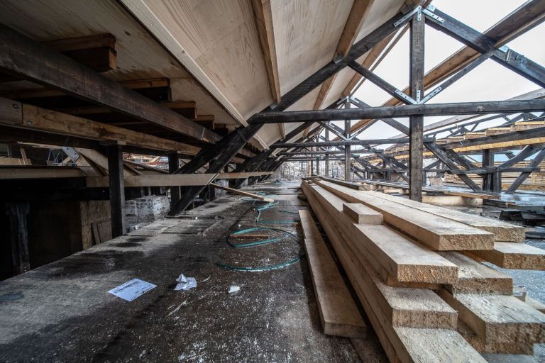 Dachraum mit Holzbalken, Stahlverbindungen und gelagerten Kanthölzern