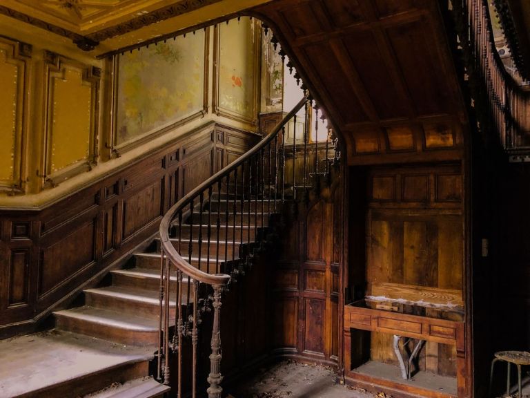 Altes Treppenhaus mit hölzernem Geländer und Wandvertäfelung